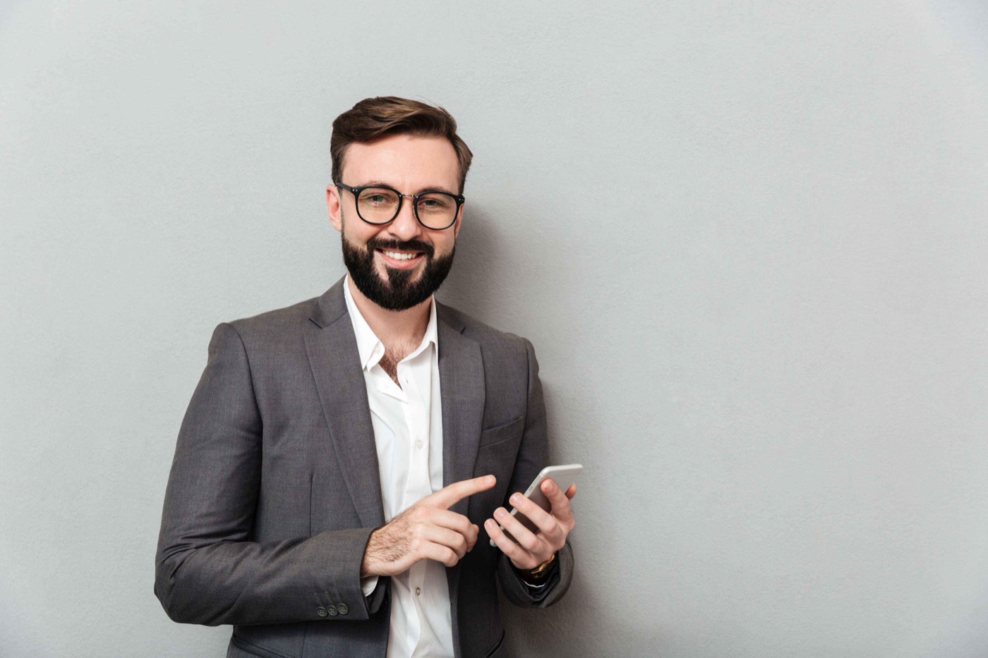 Bearded team member in glasses holding a phone