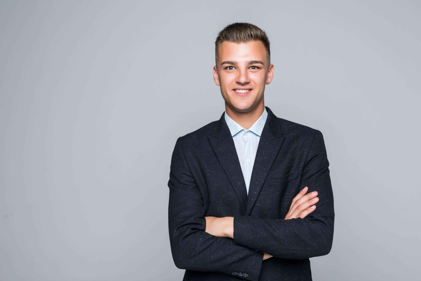 Team member in a dark blazer with arms crossed
